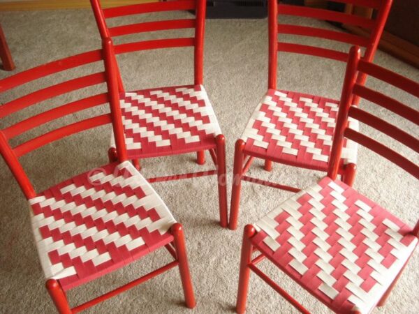 Four red chairs with Shaker tape seats in a red and white twill pattern. 